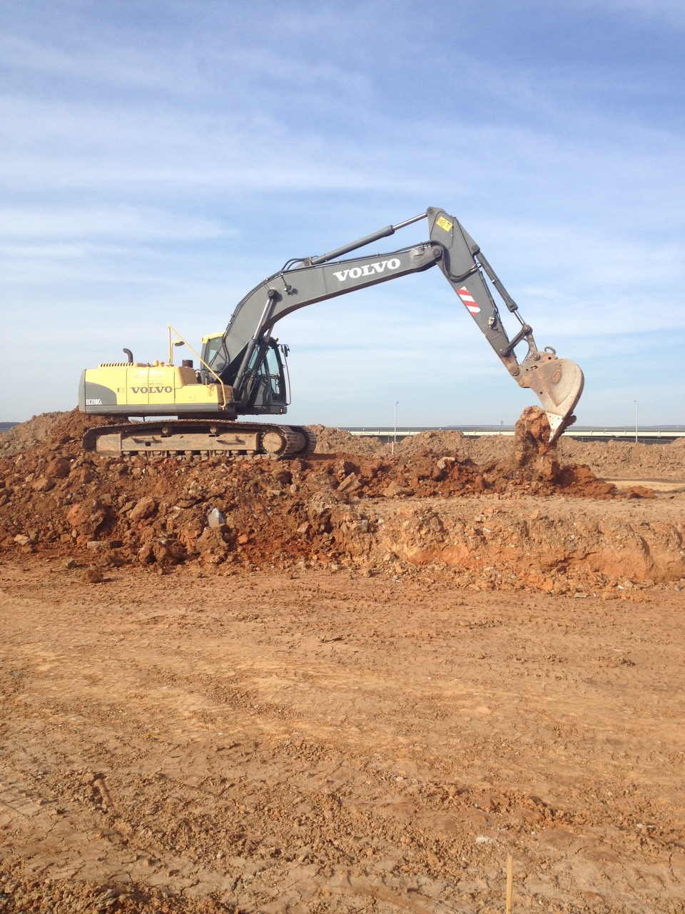 Excavator working in an open earthwork area